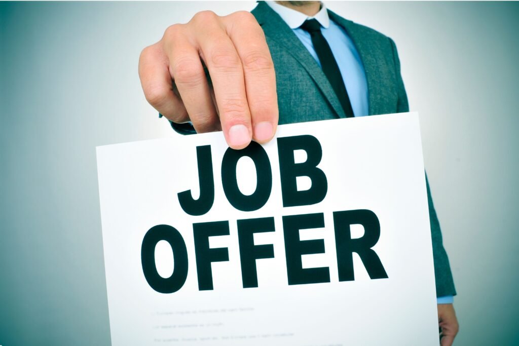 Empresário segurando uma placa de oferta de emprego.