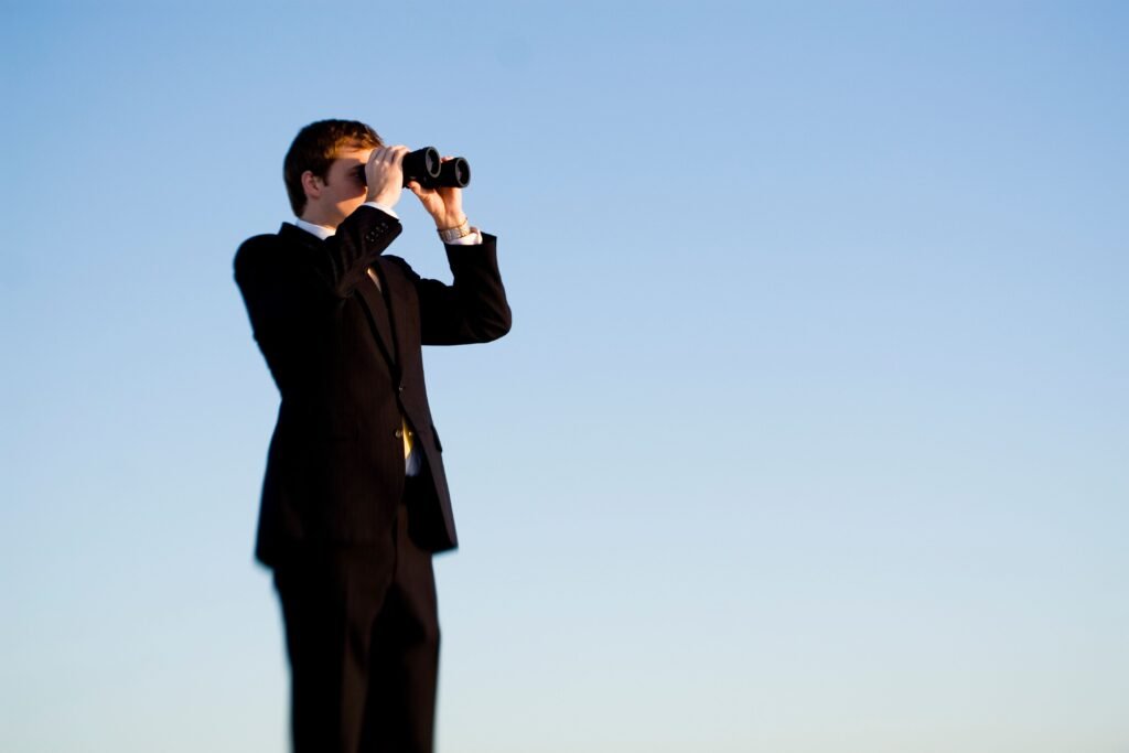 Pessoa procurando algo com um binóculo.