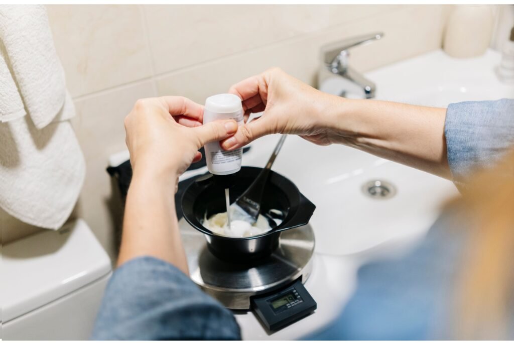 Pessoa colocando tinta de cabelo em um recipiente. 