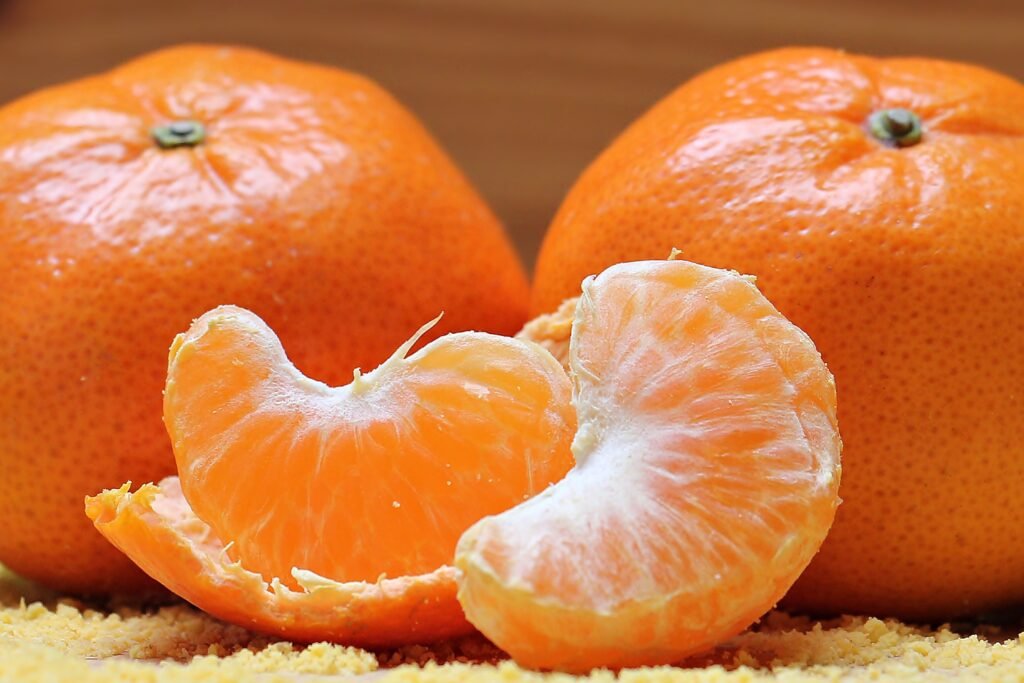 Três tangerinas inteiras e uma cortada em gomos.