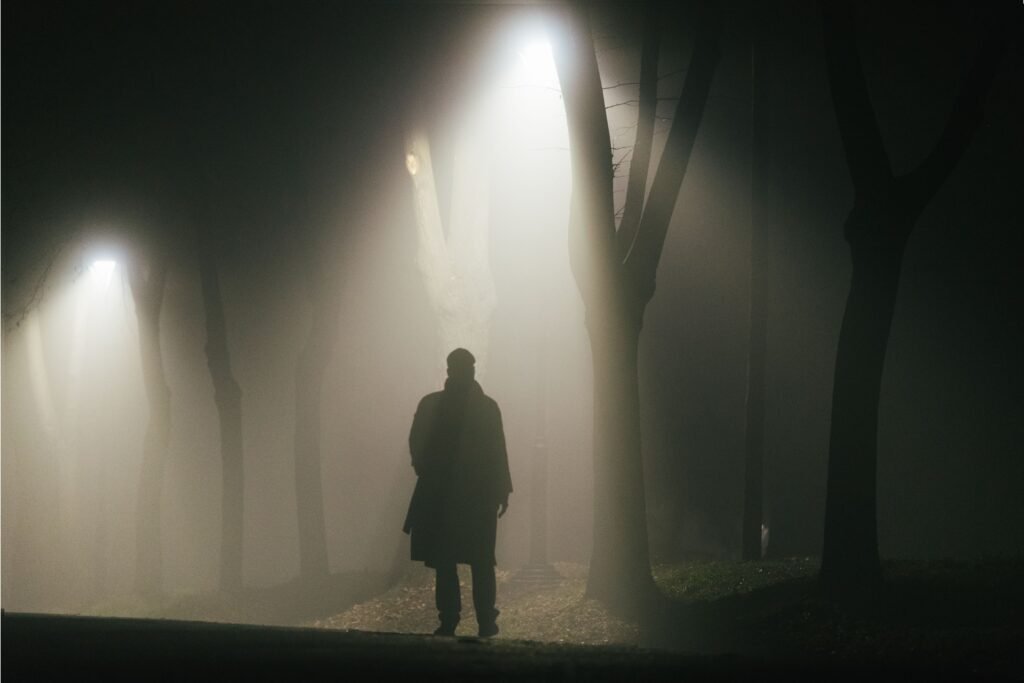 Homem caminhando na escuridão.