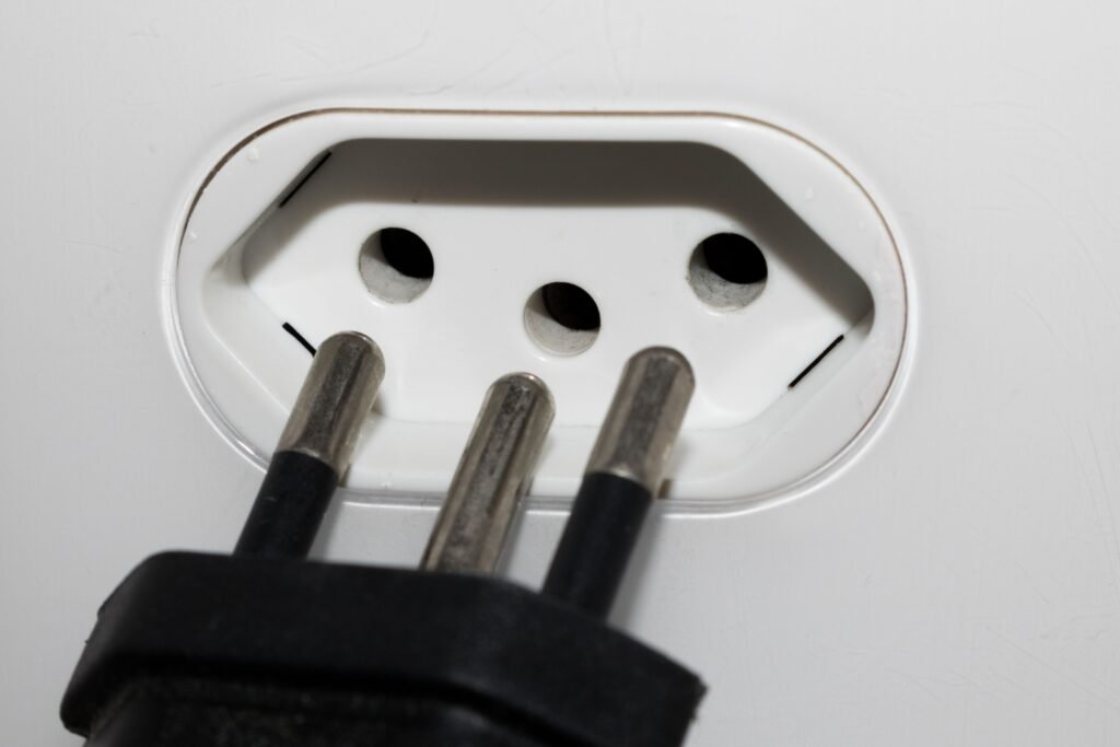 Plug de três pinos padrão brasileiro.