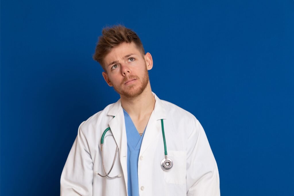 Médico com jaleco branco em um fundo azul escuro. 