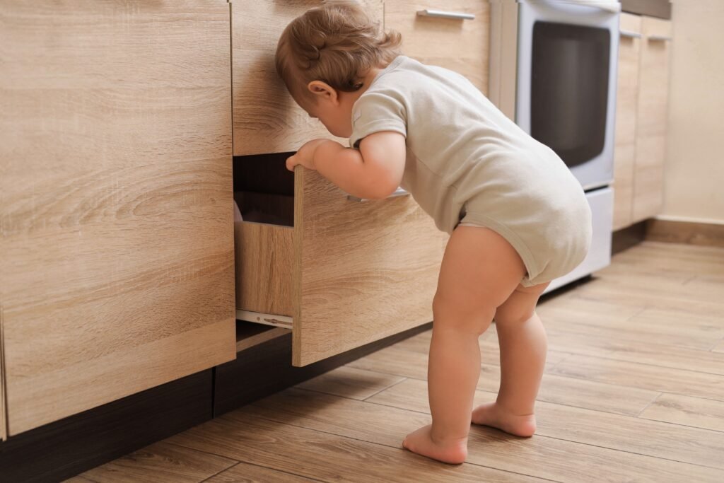 Criança mexendo em uma gaveta de cozinha.