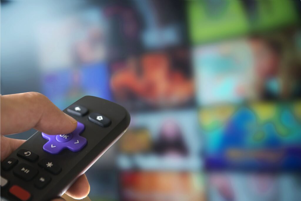 Pessoa com controle de roku na mão.