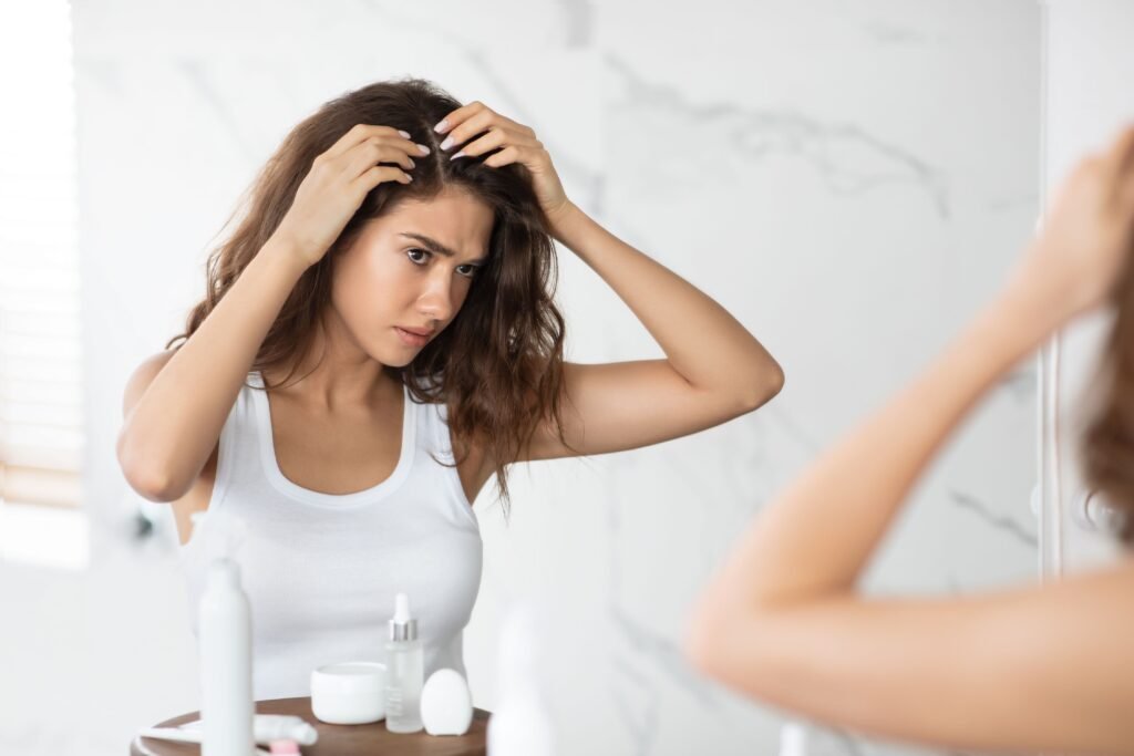 Mulher verificando a presença de caspas no cabelo.