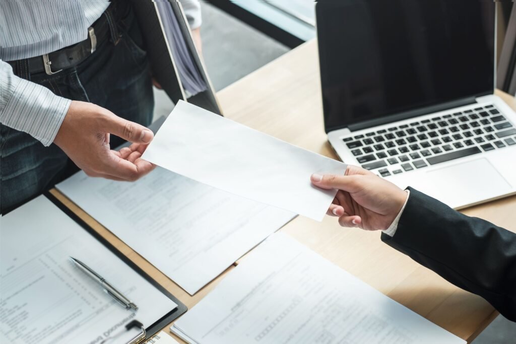 Chefe entregando um documento de demissão para o funcionário.