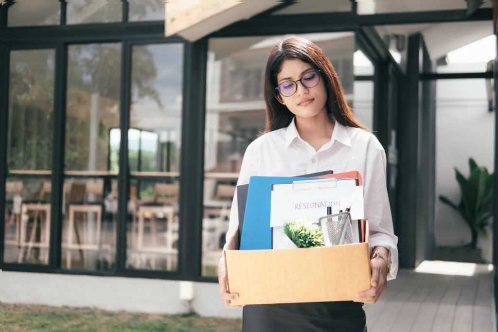 Mulher carregando seus pertences em uma caixa.