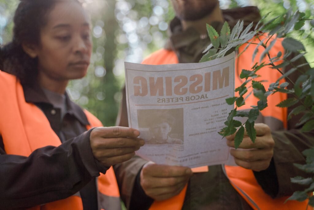 Pessoas olhando o cartaz de um menino desaparecido.