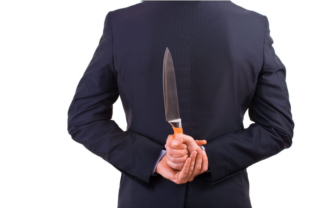 Pessoa com uma faca nas costas. 