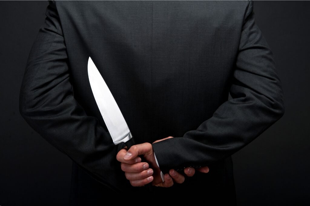 Homem segurando uma faca escondida.